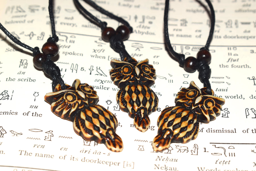 Three brown resin owl pendants on black cord with beads on Egyptian hieroglyph parchment 