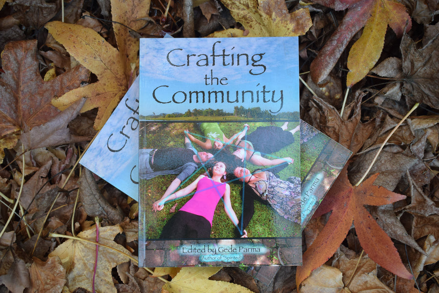 Two books titled Crafting the Community Edited by Gede Parma resting on a bed of leaves