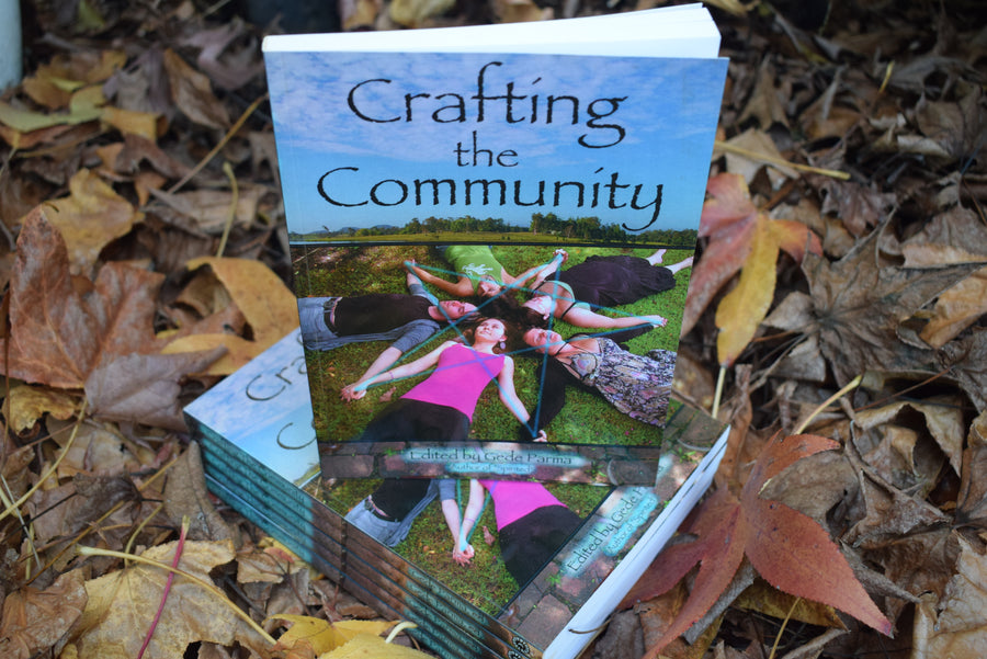 Six books titled Crafting the Community Edited by Gede Parma resting on a bed of leaves