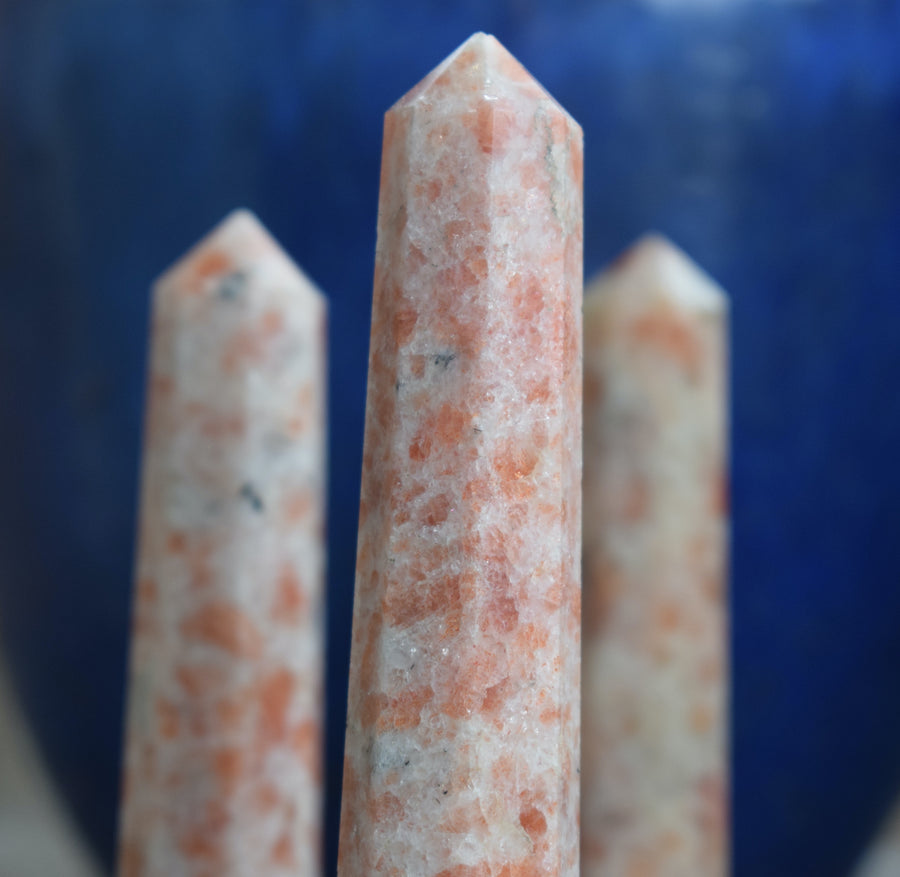 Three sunstone, heliolite or aventurescent crystal wands, points, towers or obelisks