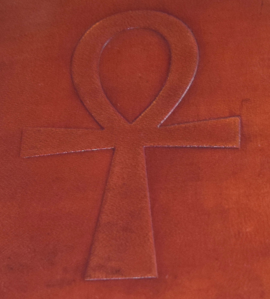 A leather-bound cover of a book with an ankh embossed on it
