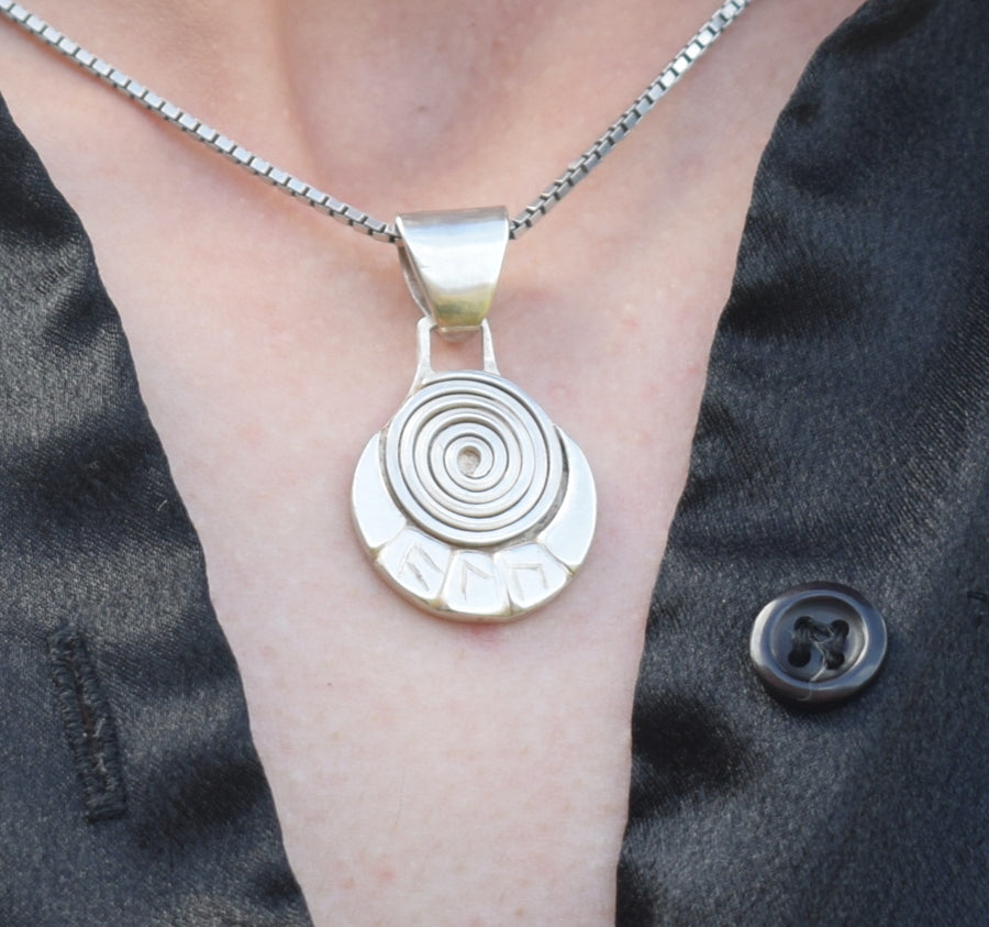 Neck with a sterling silver spiral and runic necklace and chain