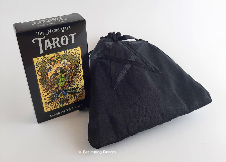 A deck of Magic Gate tarot cards sitting next to a black fabric pentagram pouch.