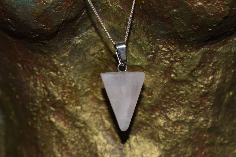 Rose quartz crystal triangle trinity pendant on sterling silver chain hanging from goddess torso sculpture 