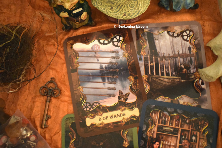 Four steampunk tarot cards laid out on an altar with a key, herbs and other mysterious items surrounding them..
