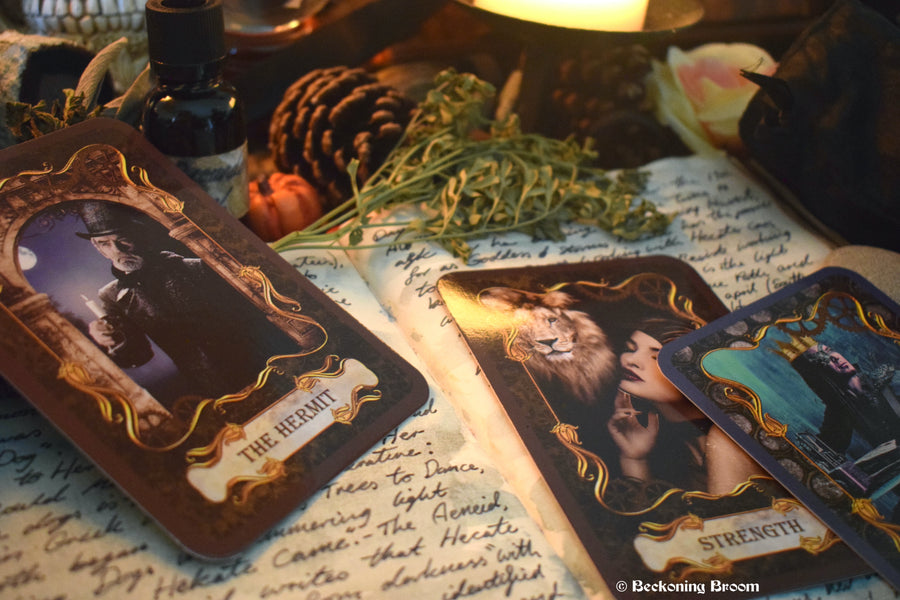 Three steampunk tarot cards laid out on an open grimoire with candles, herbs and other mysterious items surrounding.