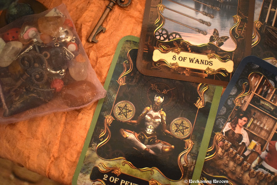 Three steampunk tarot cards laid out on an altar with a key and other mysterious items surrounding.