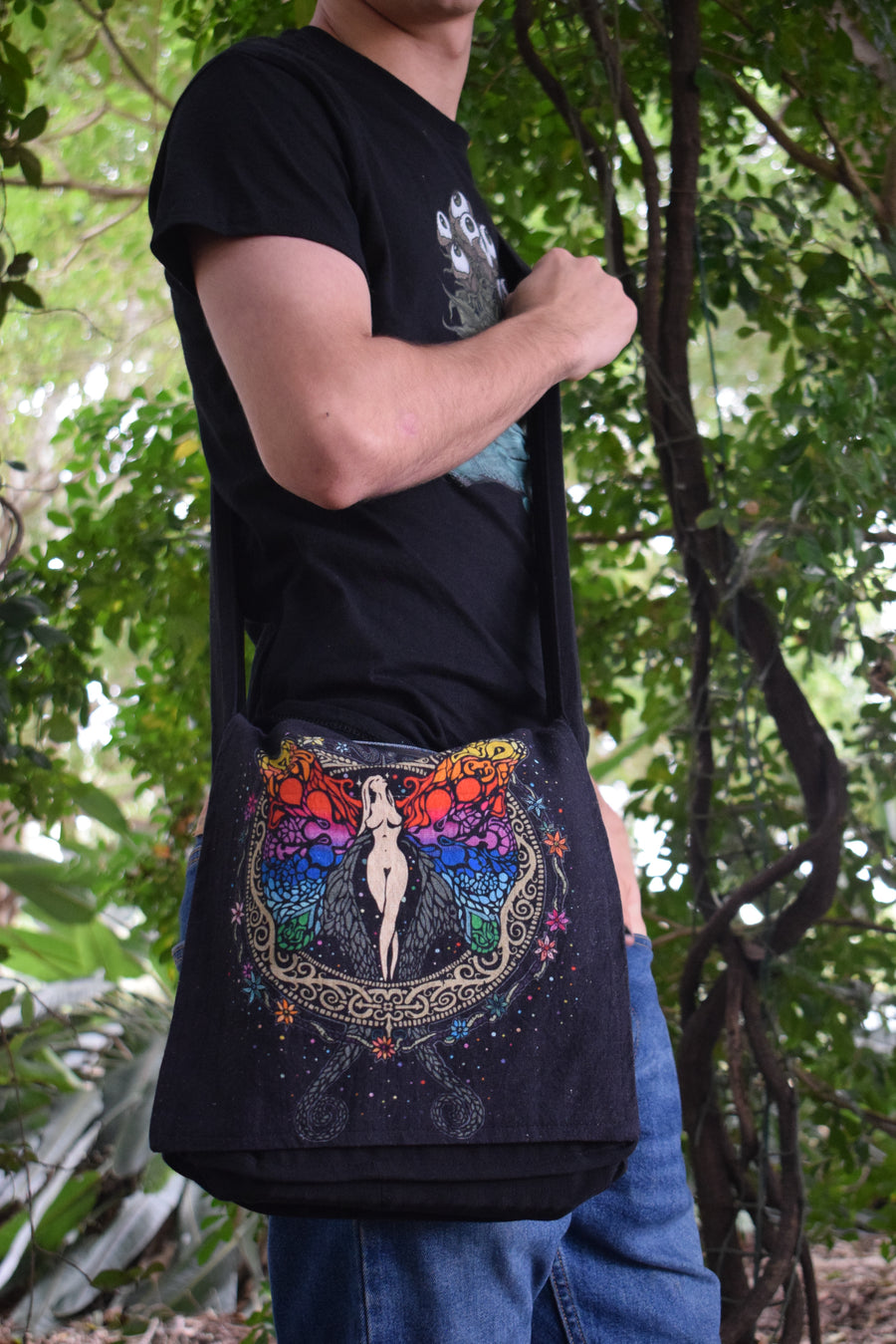 Rainbow angel, fairy, goddess printed on black shoulder bag worn on person in blue jeans and black t-shirt 