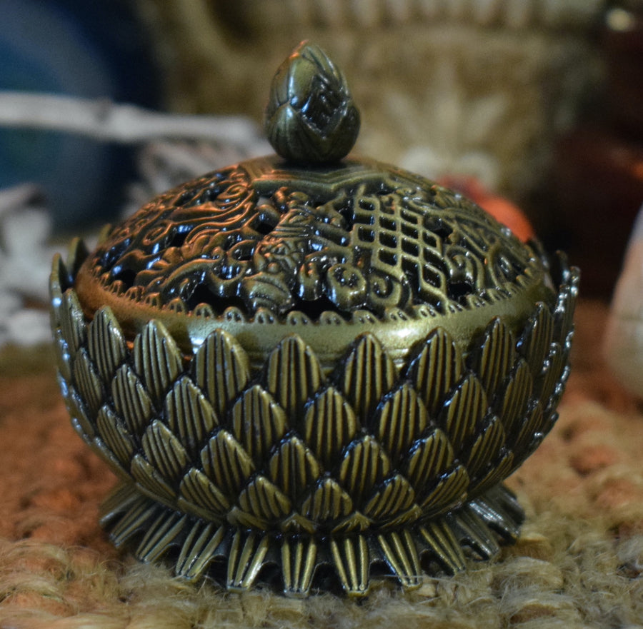 A metal lotus trinket box with a lid 