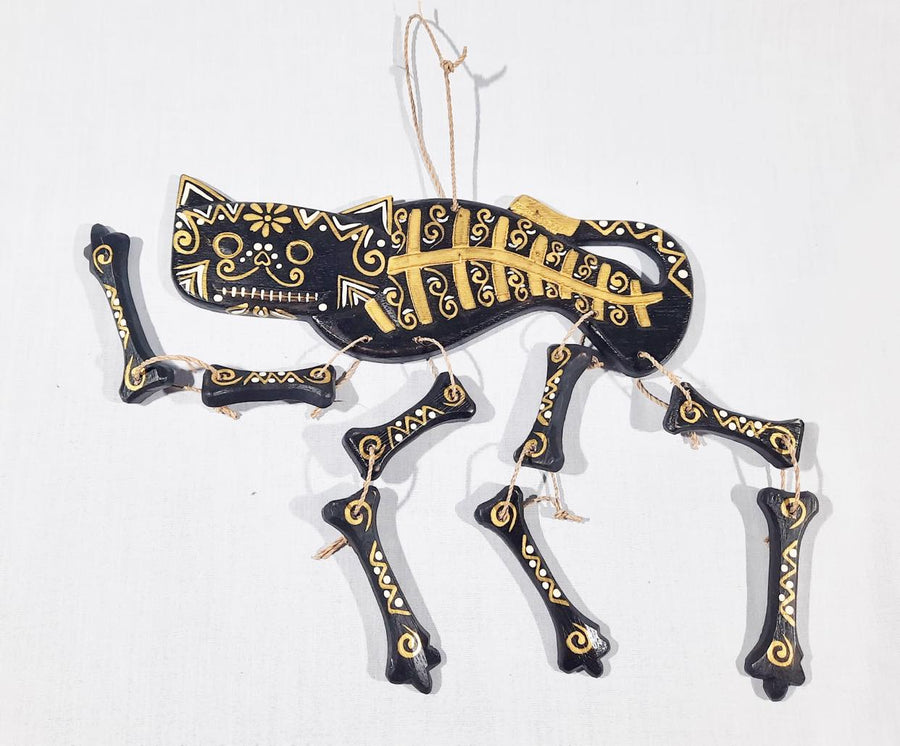 A black cat skeleton calavera spirit rattle with gold and white lying on a white background 