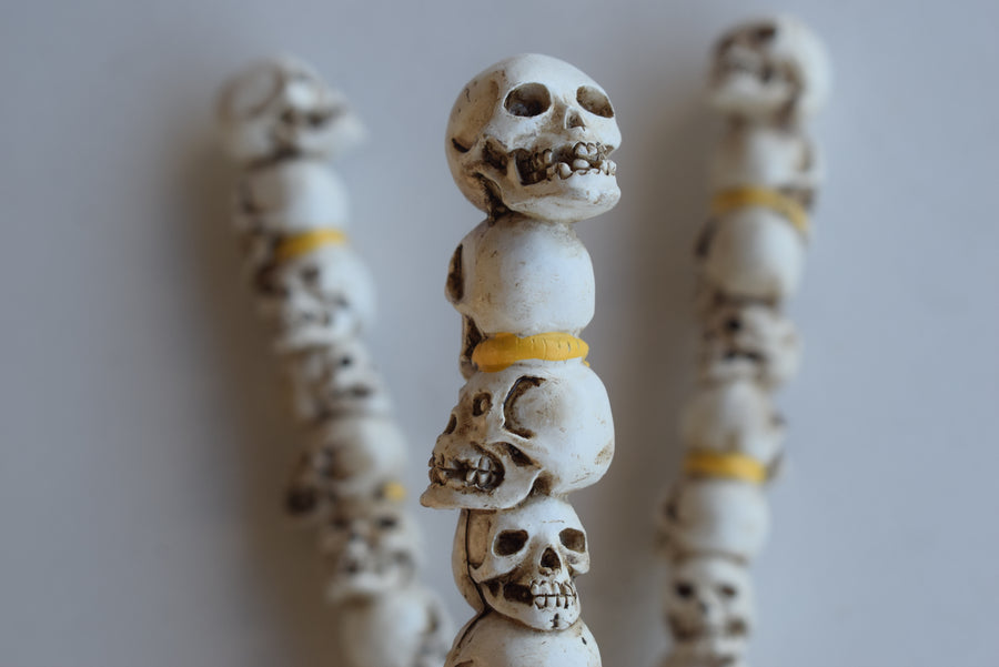 Three pens with the design of nine skulls stacked on top of one another 