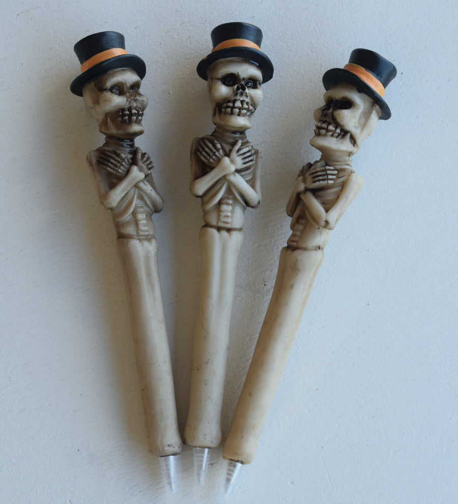 Three pens in the shape of a skeleton with arms crossed and a top hat