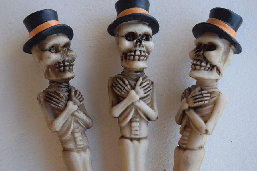 Three pens in the shape of a skeleton with arms crossed wearing top hats