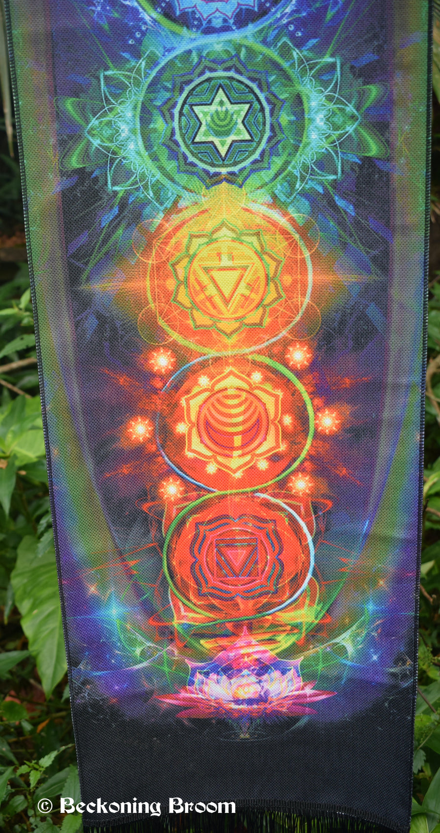 A colourful tapestry depicting chakra points hangs with greenery in the background.